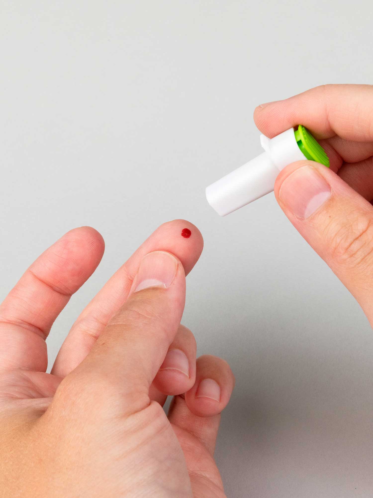 A fingertip prick drawing the blood droplet